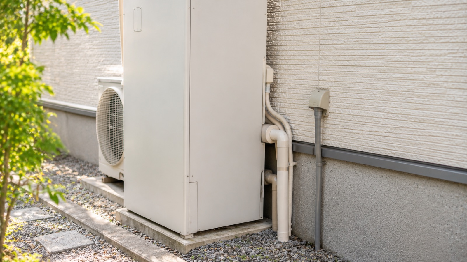 住宅の壁際に設置されたエコキュートの貯湯タンクと配管まわり